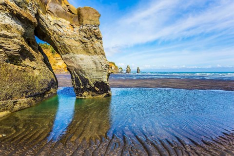 Coastal rock arches Three Sisters and Elephant on the Pacific coast. The concept of active and