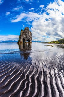 Ocean tide at sunset. The north coast of Iceland. Rock Hvitserkur on the sea beach in the form of a
