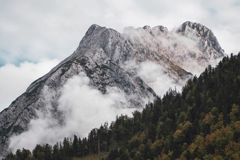 Eng, Tyrol, Austria, Rocky mountains, surrounded by fog and clouds, forest on the slopes