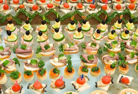 A lot of canapes with skewers and sandwiches on buffet table, shallow DOF