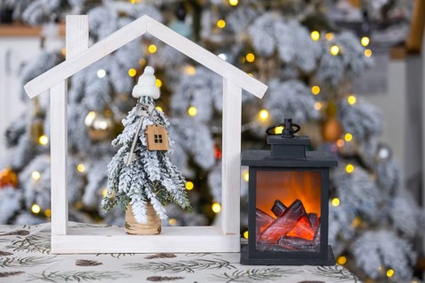 Key on Christmas tree and tiny house on cozy home with Christmas decor on table of festive white