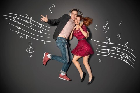 Happy valentines love story concept of a romantic couple sharing headphones and listening to music