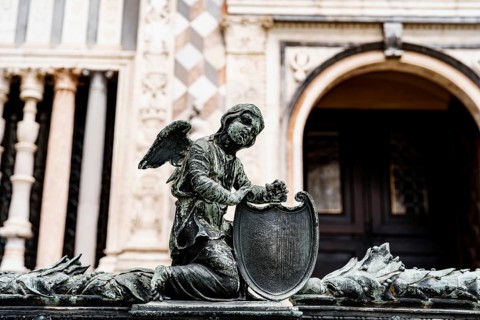 Statue of an angel with a shield near the entrance to the Colleoni Chapel. Bergamo, Italy.