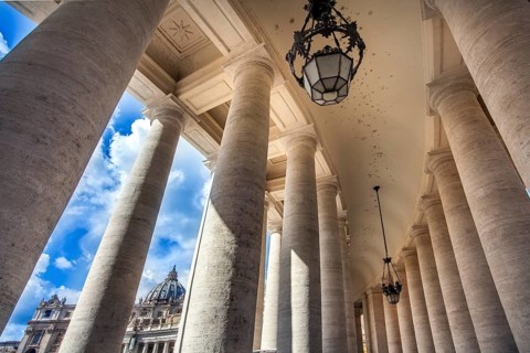View through the colonnades at St. Peter's Square to St. Peter's Basilica in Rome Lazio Italy