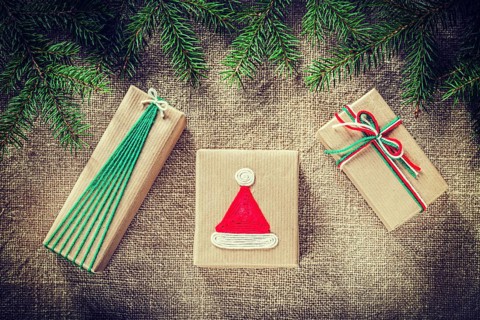 Green pine tree branches handmade gift boxes on burlap background