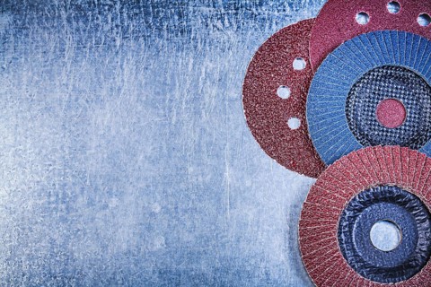 Grinding discs abrasive flap wheels on scratched metallic background copy space