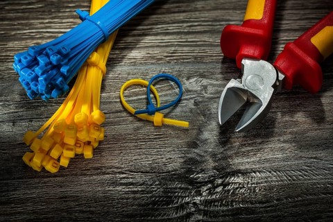 Plastic cables cutting pliers on vintage wooden board
