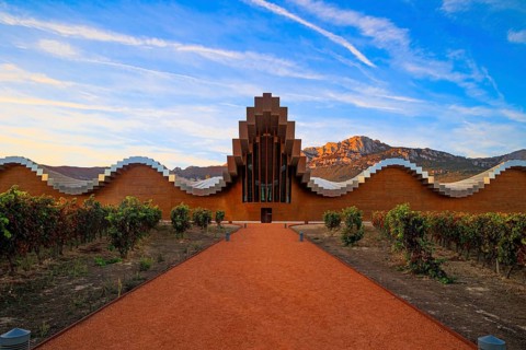 The magnificent modern architecture of Bodegas Ysios. Bright flaming colors of the sunset. Journey