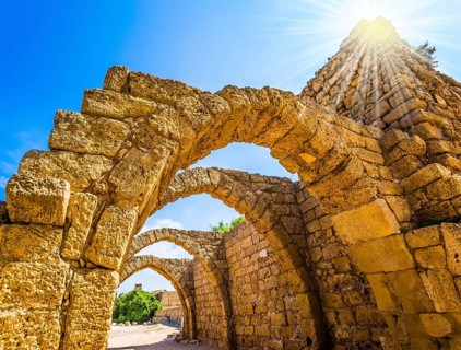 Dazzling spring sun illuminates the ancient Mediterranean port. The remains of the covered arcades
