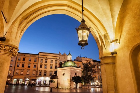 City of Krakow by night in Poland, Ranaissance arch of the Cloth Hall (Sukiennice), St. Adalbert