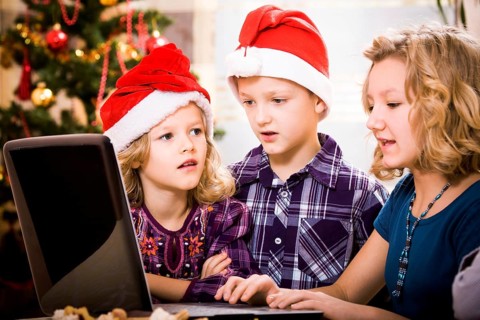 Kids surfing with a laptop at the christmas tree