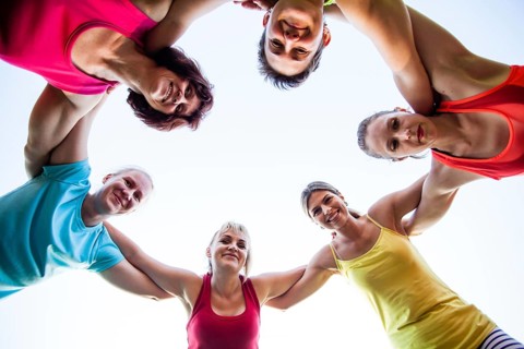 Close-up of fit girls putting hands on top of each other as symbol of successful collaboration
