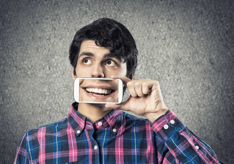 Young man holding smartphone with smile on screen