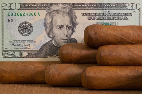 Luxury Cuban cigars with US dollar banknote on the wooden table