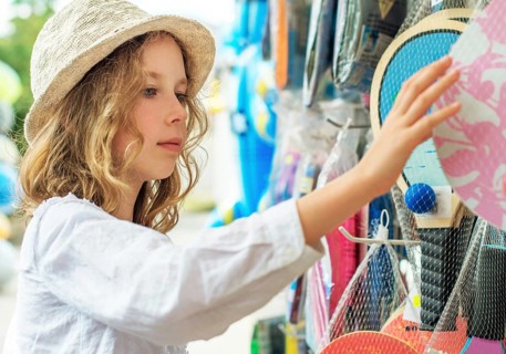 Little girl is choosing table tennis racket for vacations