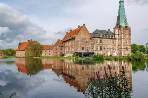 An old castle with a striking tower, reflected in a calm lake, Raesfeld, westphalia, germany
