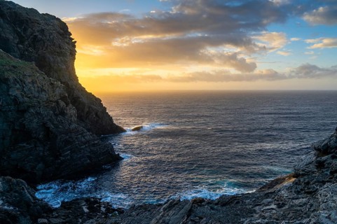 Long exposure sunset seascape with rocks and reef at Capo Falcone in Sardinia