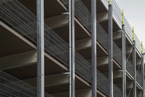 Modern parking garage levels with metal grid railing and support structure