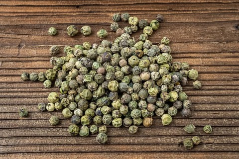 Dried spices green pepper. Peppercorn on a wooden board