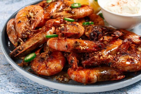 Grilled shrimps served with hot sauce and slices of fresh lemon, homemade, no people