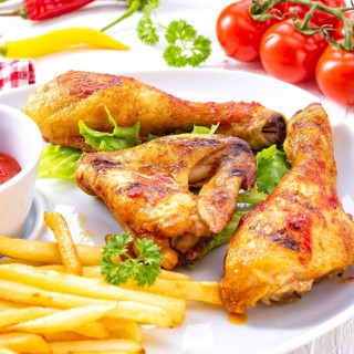 Grilled chicken wings, legs, chips and vegetables