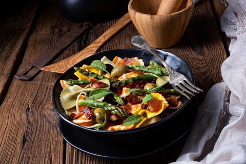 Pasta salad with green asparagus, olives and Parma ham