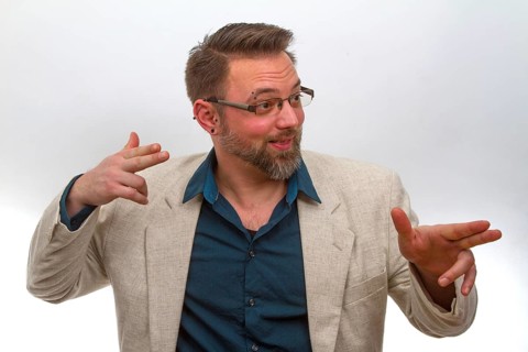 Young man points with finger on light background