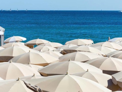 Many sunshades on the beach, symbolic photo for holidays, mass tourism, sunburn Austria
