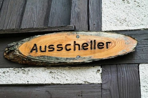 Wooden sign with Ausscheller lettering on a wooden beam