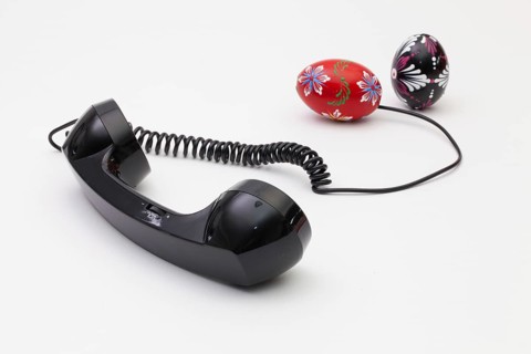 Old phone reciever and cord connection with Easter eggs. Easter hotline concept