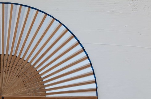 Typical Japanese hand fan made on the wooden white table