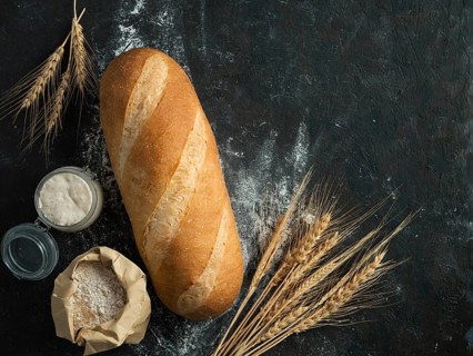 British White Bloomer or European sourdough Baton loaf bread on black background. Fresh loaf bread