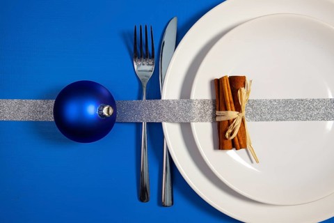 Two white plates and Christmas decoration on the blue wooden table.Top view.Flat Lay Image