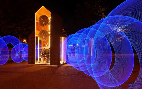 Blue light circles created with LED lights encircle an artistic large clock, Lightpaniting,