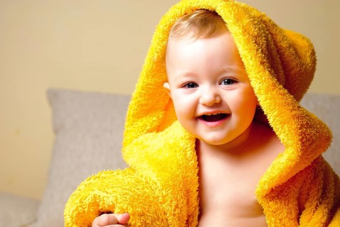 Girl after bathing, sitting in yellow bathrobe