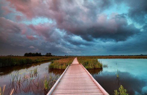 Wooden bike road on water at rainy sunset, Netherlands