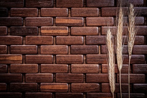Wheat and rye ears on wooden backcloth close up view
