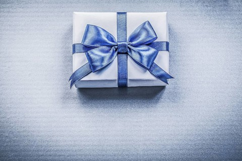 Packed present box with bow on blue background holidays concept