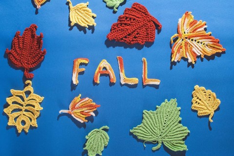 Knitted autumn leaves on blue textile