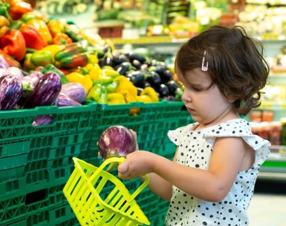 Child shopping eggplants in supermarket. Concept for buying fruits and vegetables in hypermarket.