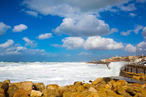 Storm on the Mediterranean Sea. Huge waves with white foam collapse at the Old Port of Jaffa in Tel