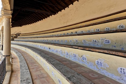 Bullring of Ronda, Plaza de Toros, Numbered rows of seats in an arena with old-style wood and stone