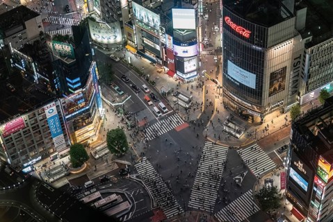 Crossroads in Shibuya in the evening from above. Numerous monitors and advertising signs illuminate