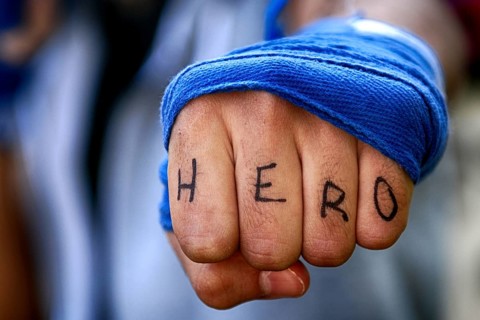 Angry mans fist punching with hero letter on the fingers water. Human power force