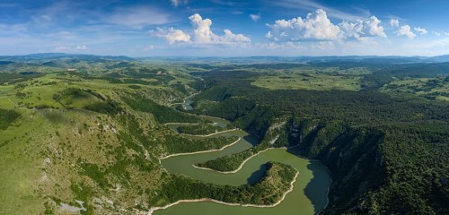 Aerial panorama of meanders at rocky river Uvac gorge on sunny day, southwest Serbia