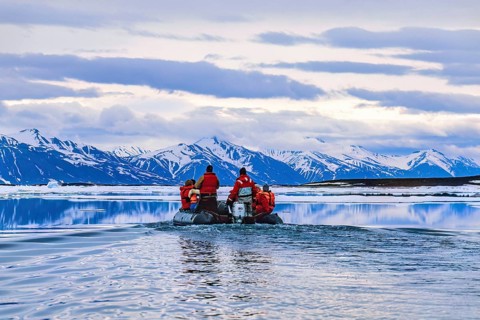 People travelling in inflatable boat at Svalbard