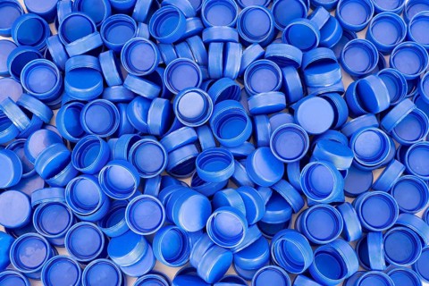 Blue plastic bottle caps. Studio shot. Plastic waste
