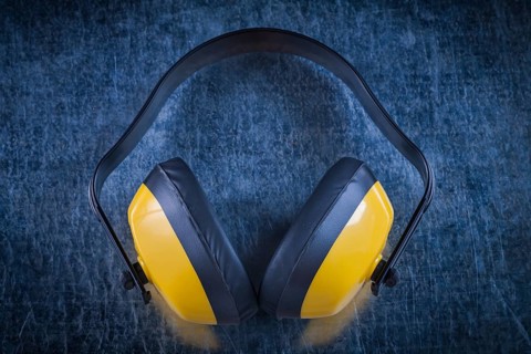 Noise reduction earmuffs on metallic surface construction concept