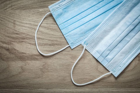 Disposable surgical face masks on wooden board