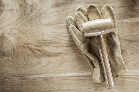 Safety gloves lump hammer on wooden board